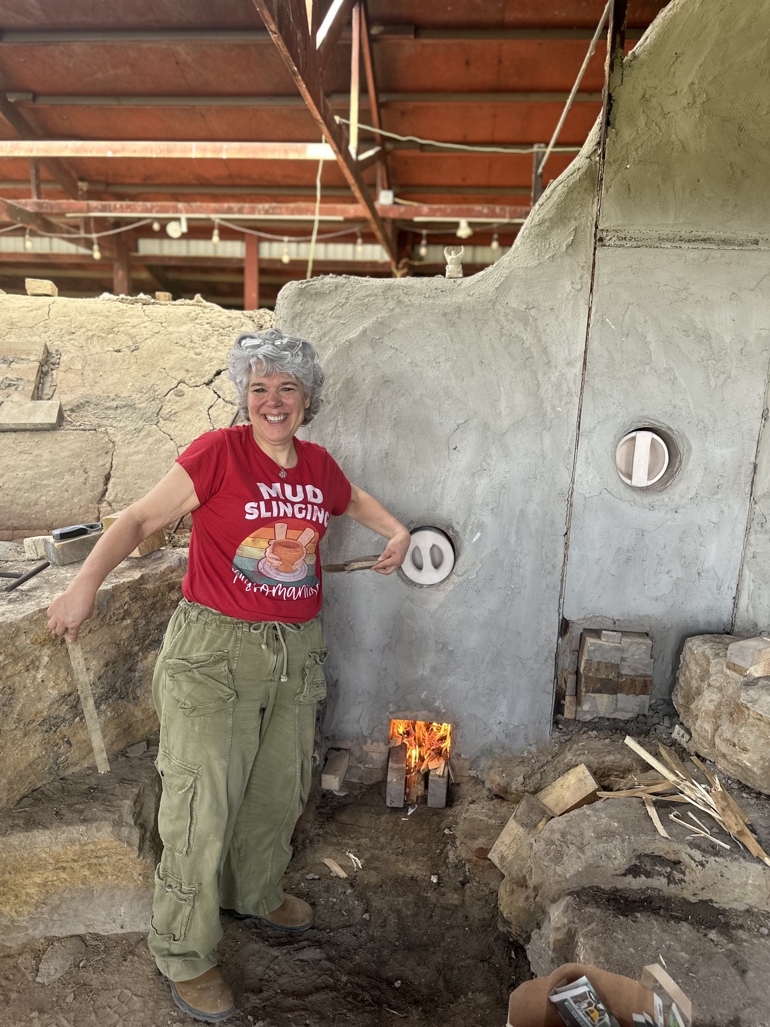Maria beside her wood-fire kiln