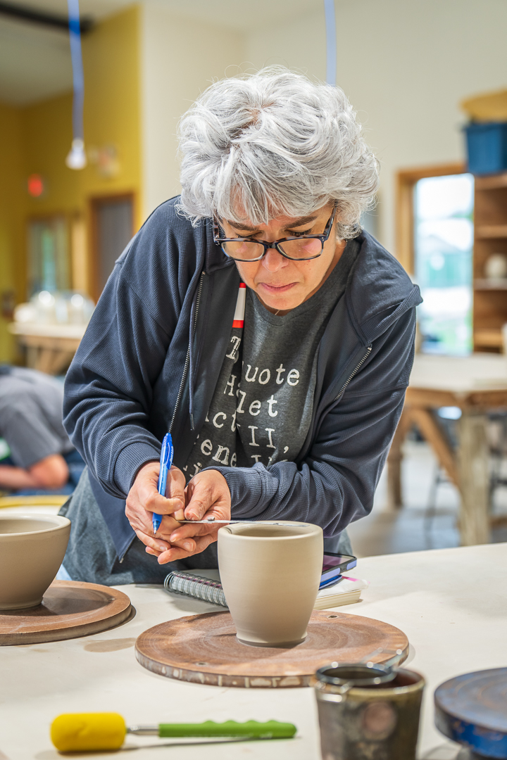 Maria trimming and detailing a piece in the studio