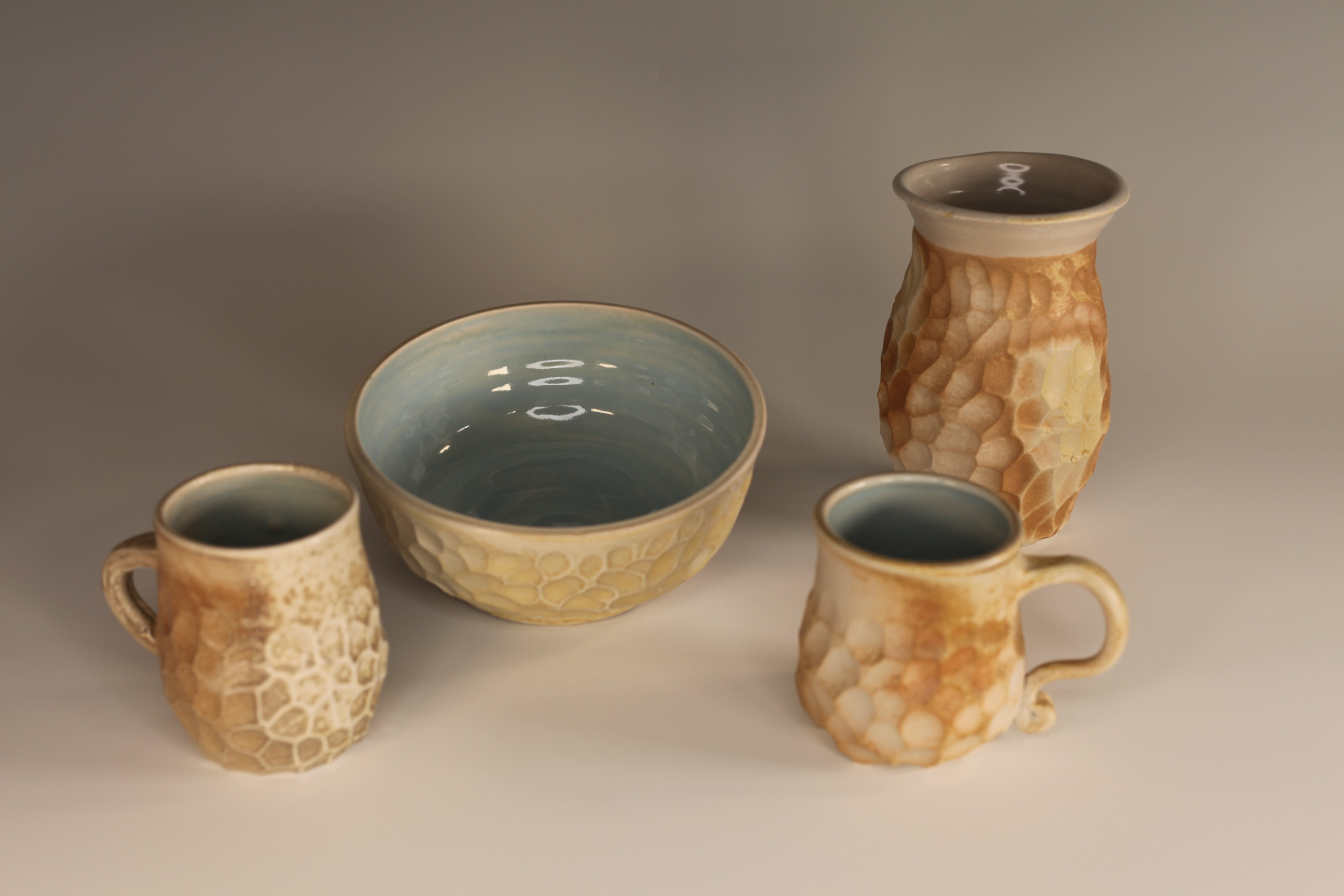 Handmade ceramic grouping with carved texture and soft neutral glaze